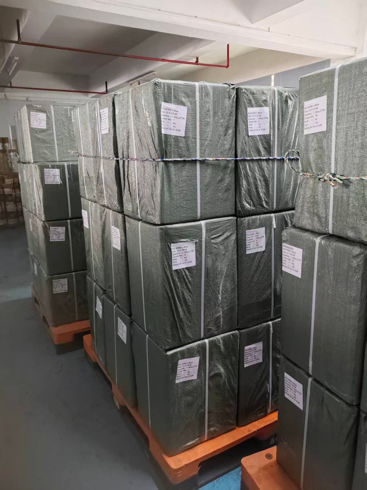 Wrapped cartons stacked on pallets, ready for delivery.
